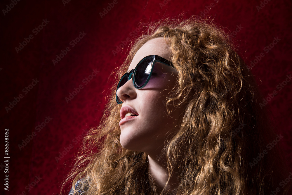Close-up portrait of beautiful pensive girl with curly hair wear