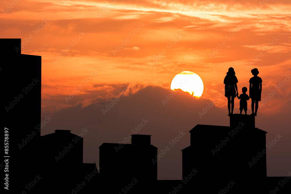 silhouette of high old building and the three child standing and looking forward on sky sunset background