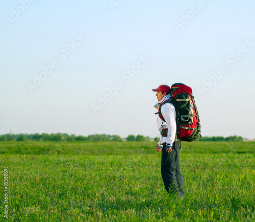 Hiker with backpack standing in the field