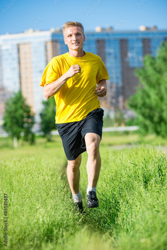 Sporty man jogging in city street park. Outdoor fitness. Sporty man jogging in city street park. Outdoor fitness.