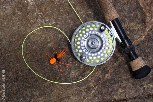 Fly Rod and Orange Spider Fly on a Dry Rock photo