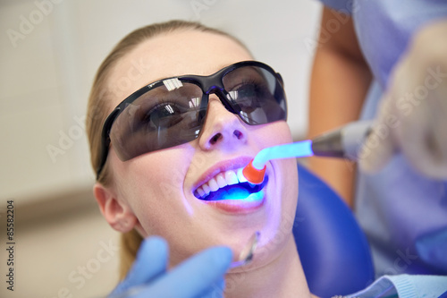 Foto close up of woman patient with dental curing light