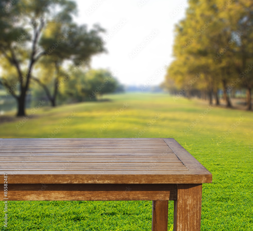 Fototapeta premium empty free space top wood table on green grass field against sun