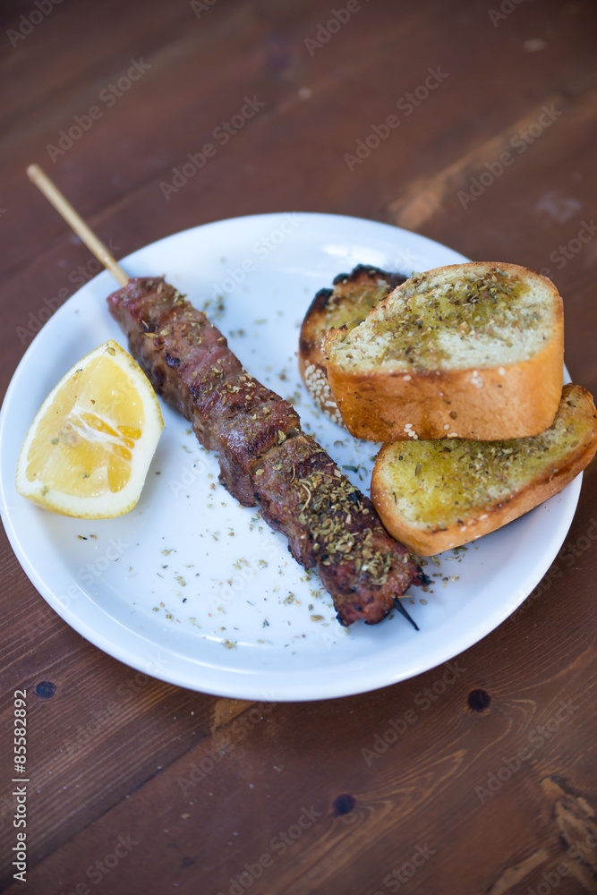 meat skewers (souvlaki) with lemon and bread, Greek traditional cuisine meat skewers (souvlaki) with lemon and bread, Greek traditional cuisine