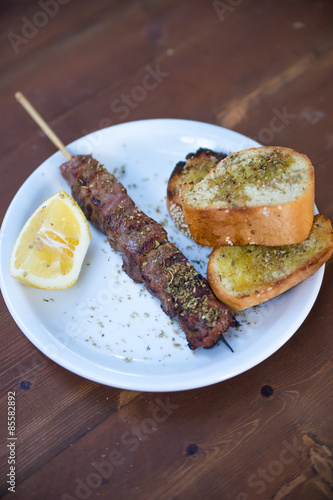 meat skewers (souvlaki) with lemon and bread, Greek traditional cuisine