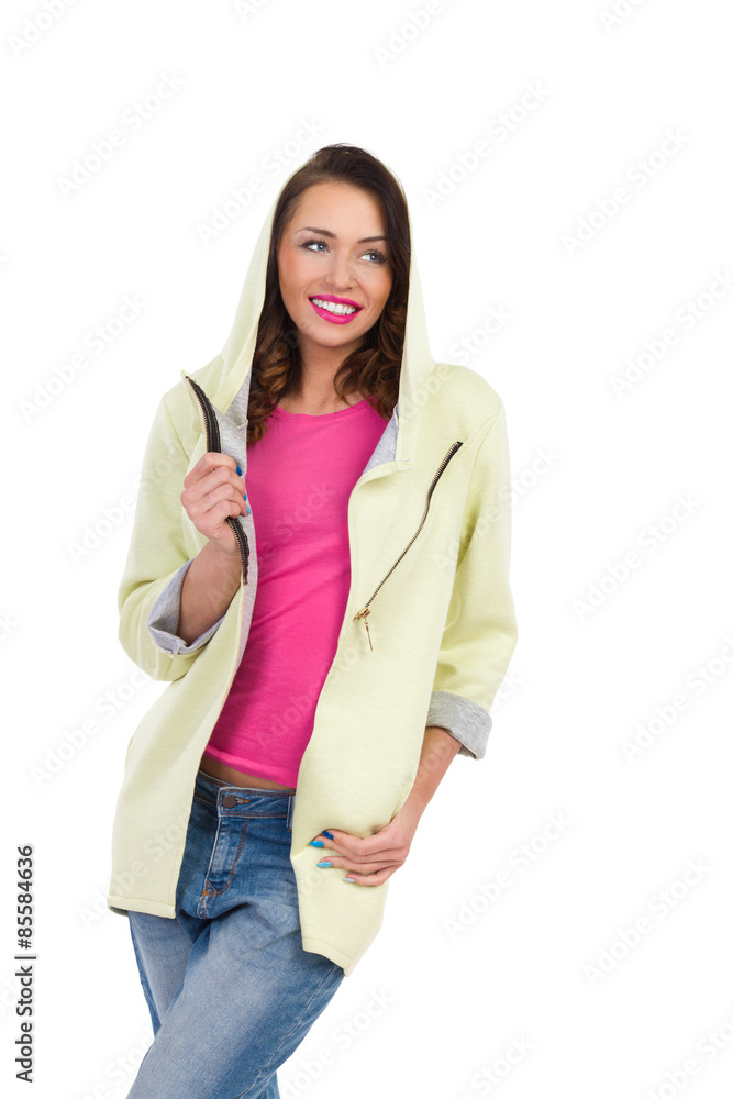 Smiling young woman posing in hoodie and looking away. Three quarter length studio shot isolated on white. Smiling young woman posing in hoodie and looking away. Three quarter length studio shot isolated on white.