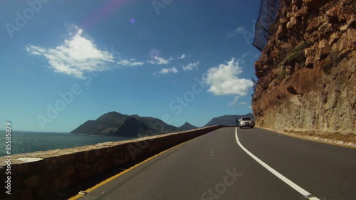 Timelapse of a car driving up Chapman's Peak on a sunny day photo