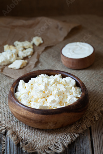 Traditional homemade cottage cheese with sour cream in rustic