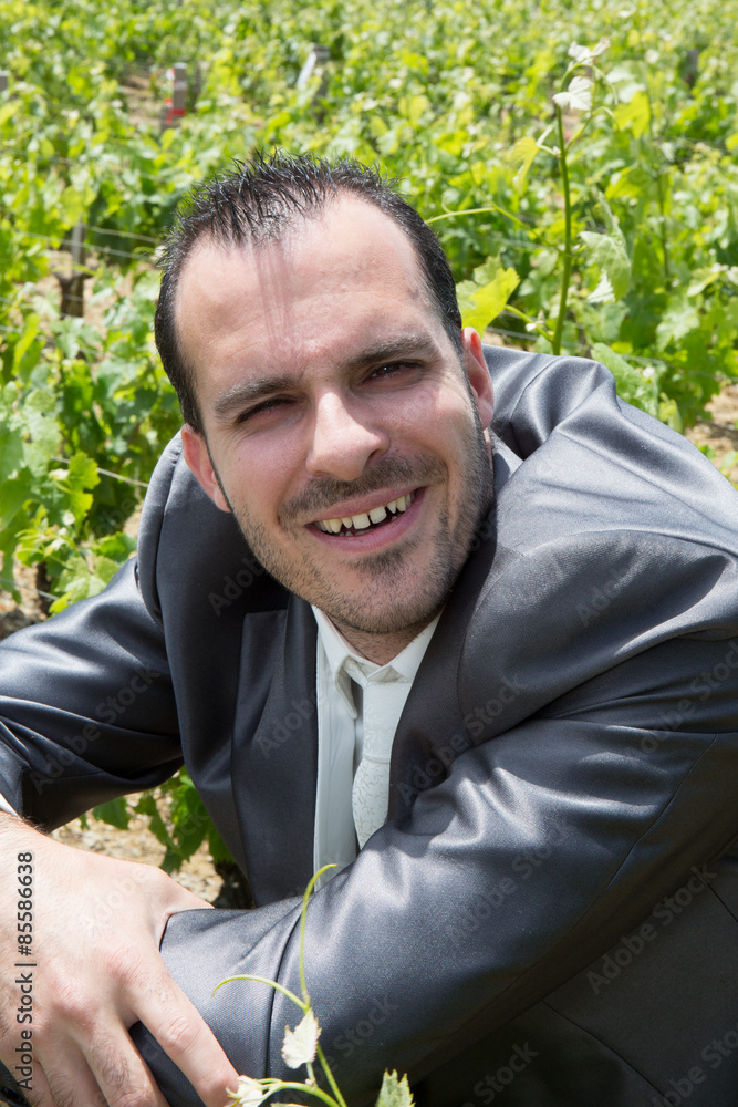 An attractive man poses for a portrait outside at a winery vineyard An attractive man poses for a portrait outside at a winery vineyard
