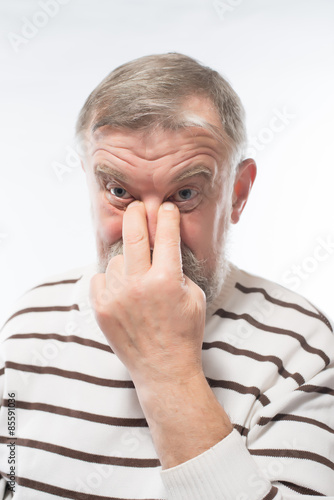 Old man holding his nose, depression