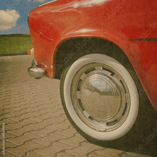 vintge red car with chrome wheel and oldscool black and white tire photo