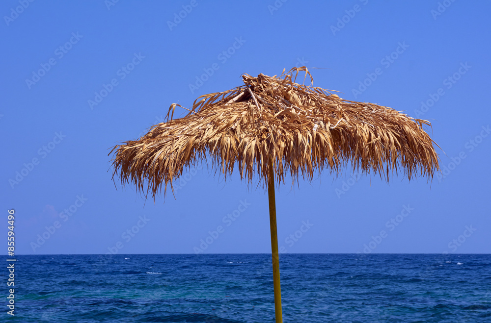 Beach umbrella by the sea on the island of Rhodes.