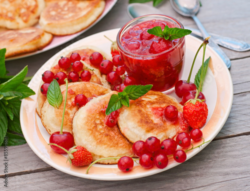 Pancakes with berries on a wooden background 