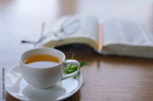Reading behind a cup of tea.