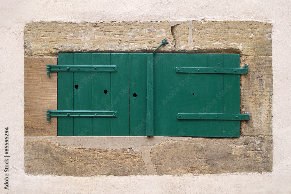Geschlossener grüner Fensterladen an einem Kellerfenster Geschlossener grüner Fensterladen an einem Kellerfenster
