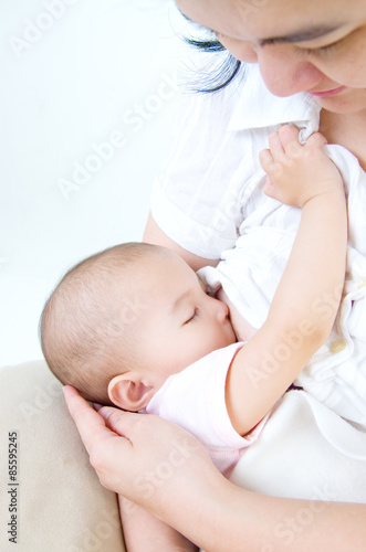 Asian mother breastfeeding her baby girl