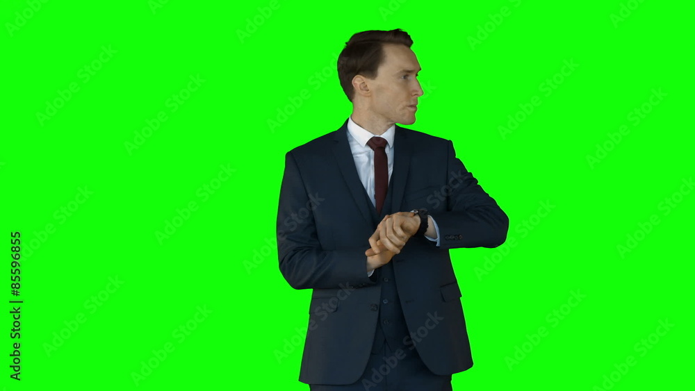 Businessman checking time on green screen Businessman checking time on green screen