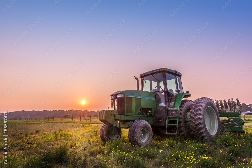 Fototapeta premium Tractor in a field on a Maryland farm at sunset