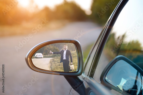 Hitchhiking man in the rearview mirror
