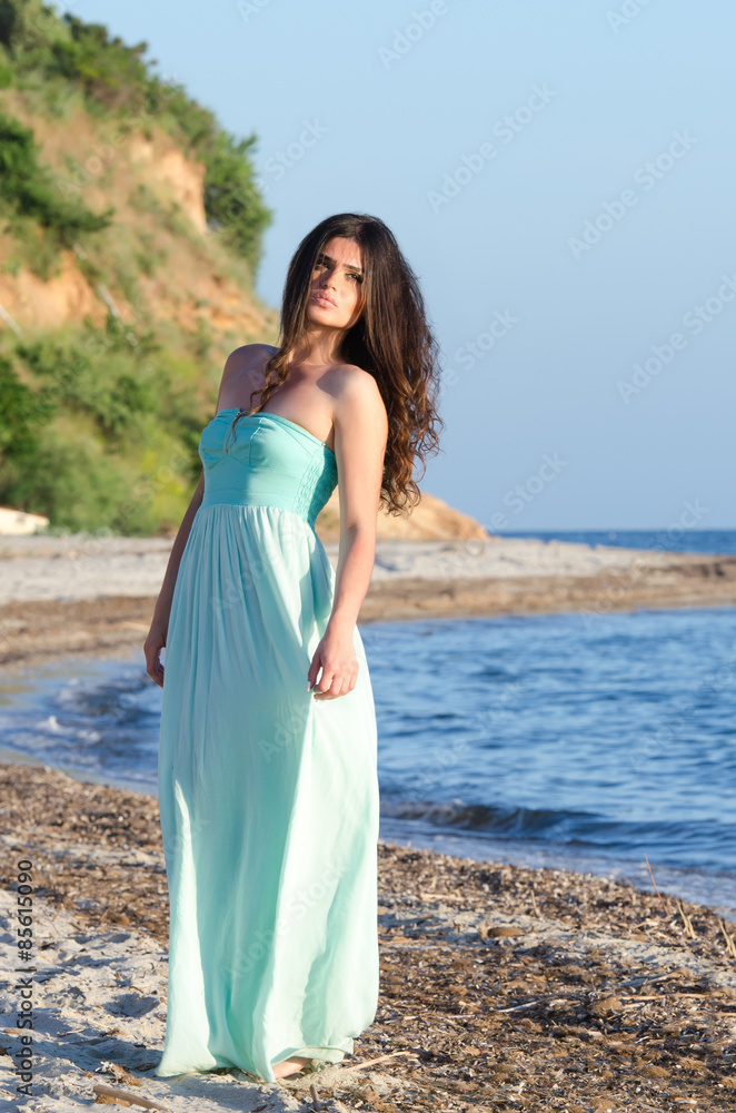 Portrait of woman at the beach wearing long coral dress Portrait of woman at the beach wearing long coral dress