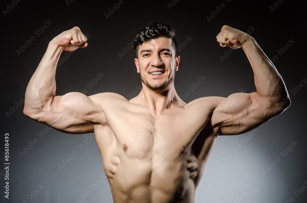 Muscular man posing in dark studio Muscular man posing in dark studio