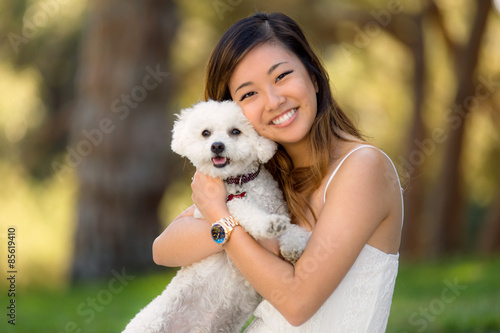 Photography Cute girl with white dog smiling and hugging at the park outdoors