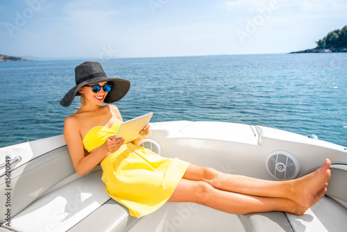 Woman relaxing with digital tablet on the yacht