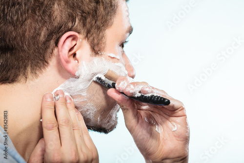 Man shaving with razor face profile