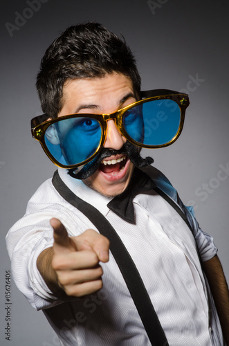 Young man with false moustache and large sunglasses isolated on