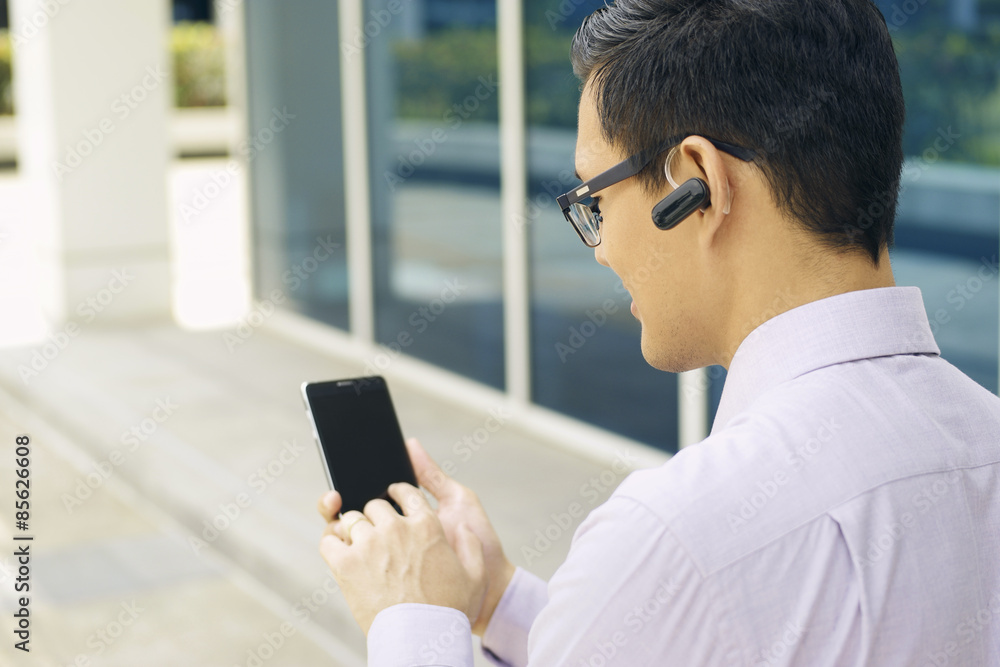 Businessman Calling On Mobile Phone With Bluetooth Handsfree Businessman Calling On Mobile Phone With Bluetooth Handsfree