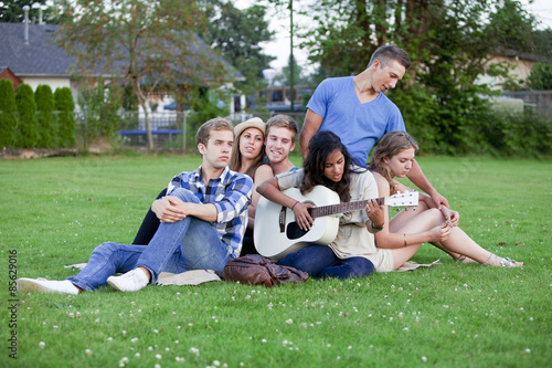 Group of young adult friends hanging out in a park.