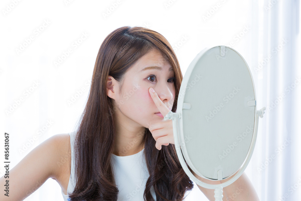 鏡　目元を気にする女性