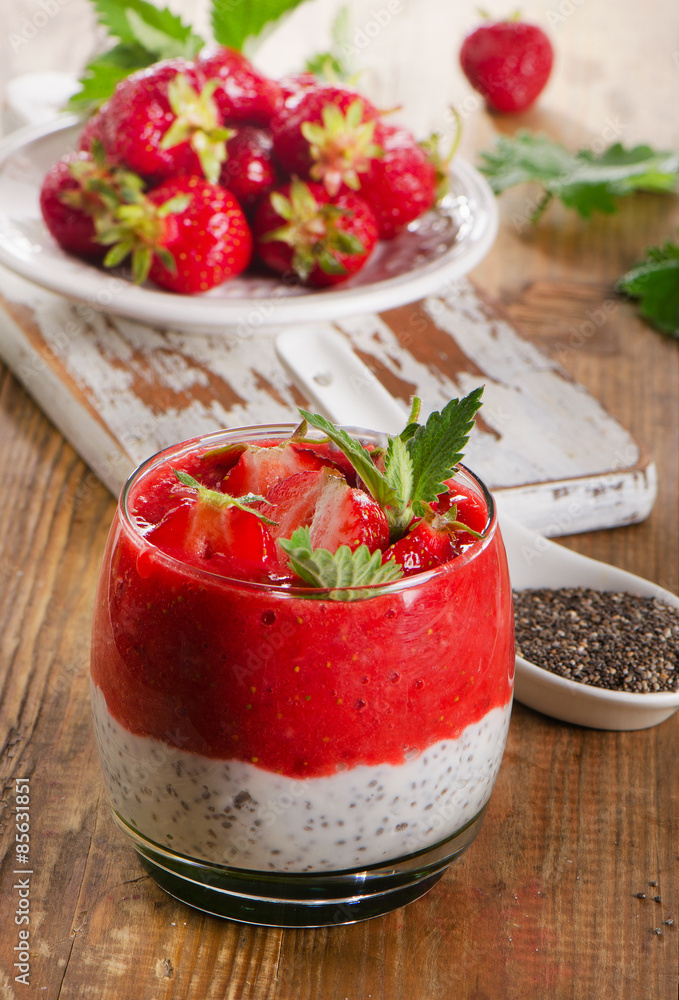 Chia seed pudding with strawberries on a rustic wooden table. Chia seed pudding with strawberries on a rustic wooden table.