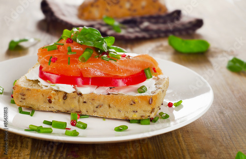 Sandwich with cereals bread and salmon on old wooden background.