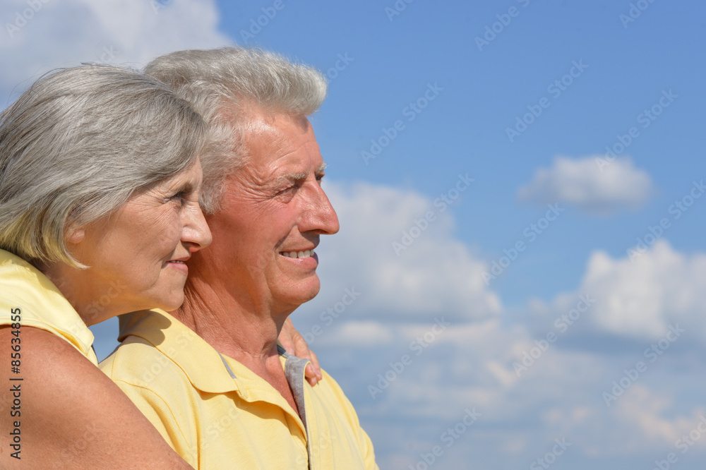 elderly couple posing against the sky