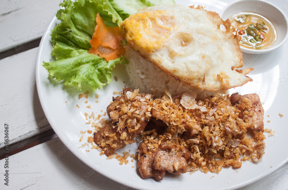 Fried pork with crispy garlic on rice + Fried egg Fried pork with crispy garlic on rice + Fried egg
