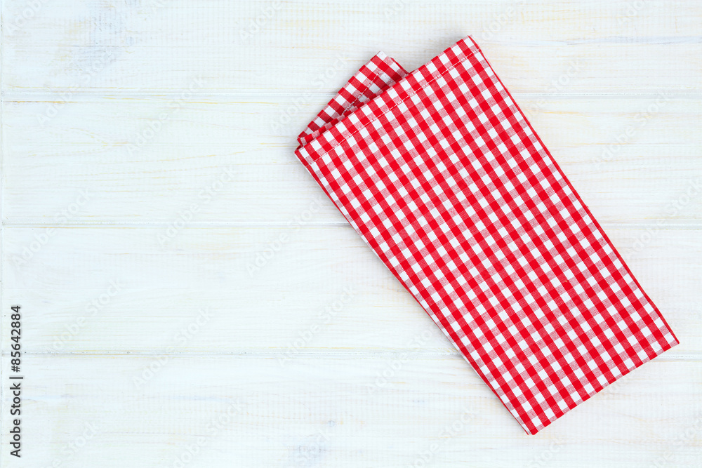 Obraz premium Red towel over wooden kitchen table. View from above with copy s