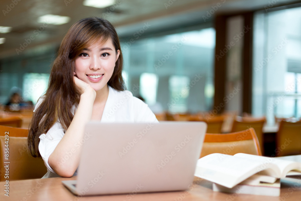 Asian beautiful female student study in library with laptop Asian beautiful female student study in library with laptop