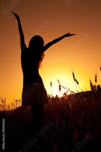 Silhouette of woman enjoying sunset