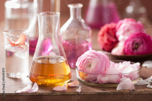 Fototapeta Naklejka Na Ścianę i Meble -  alchemy and aromatherapy set with ranunculus flowers and flasks