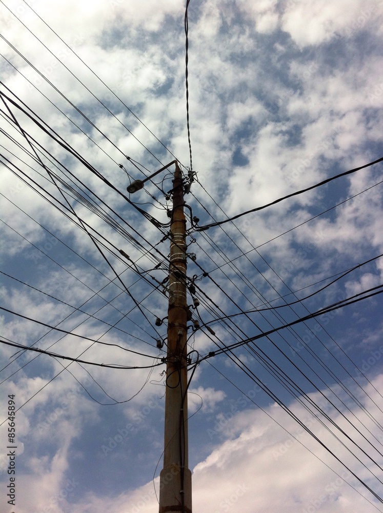 the pole with electric wires against the background of the cloudy skies the pole with electric wires against the background of the cloudy skies