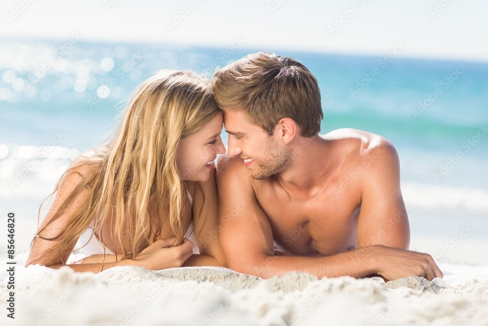 Happy couple relaxing together in the sand Happy couple relaxing together in the sand