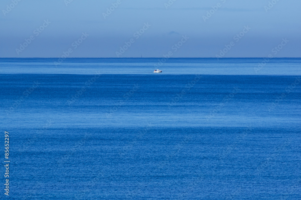 Monochromer Ozean in Blau mit weißem Schiff