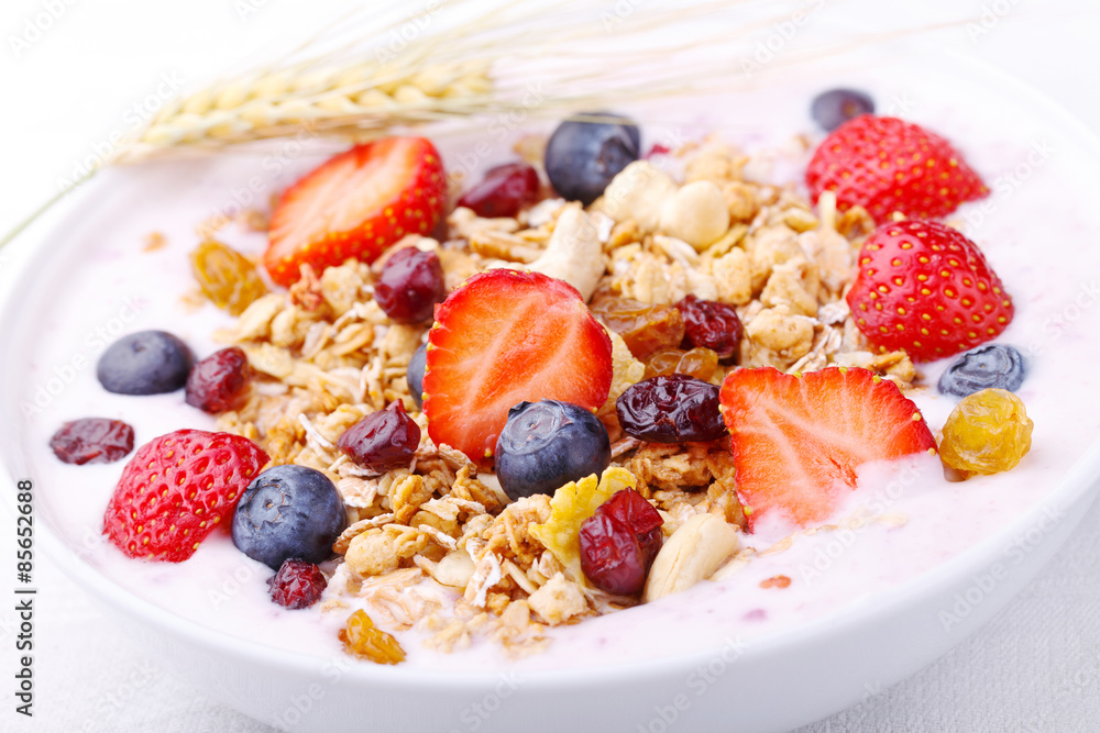 Healthy breakfast - Fresh fruits, yogurt and granola in a white bowl - Close-up Healthy breakfast - Fresh fruits, yogurt and granola in a white bowl - Close-up