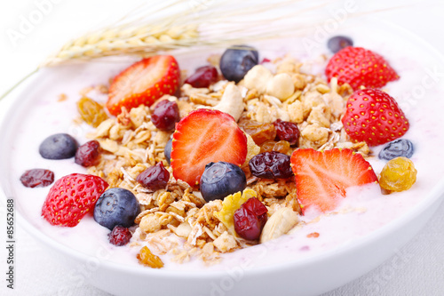 Healthy breakfast - Fresh fruits, yogurt and granola in a white bowl - Close-up 