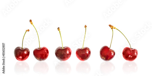 Row of cherries isolated on white background