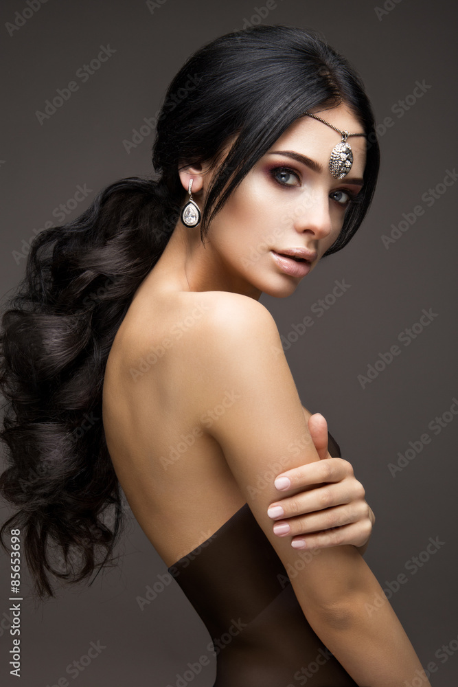 Naklejka premium Beautiful model brunette with long curled hair