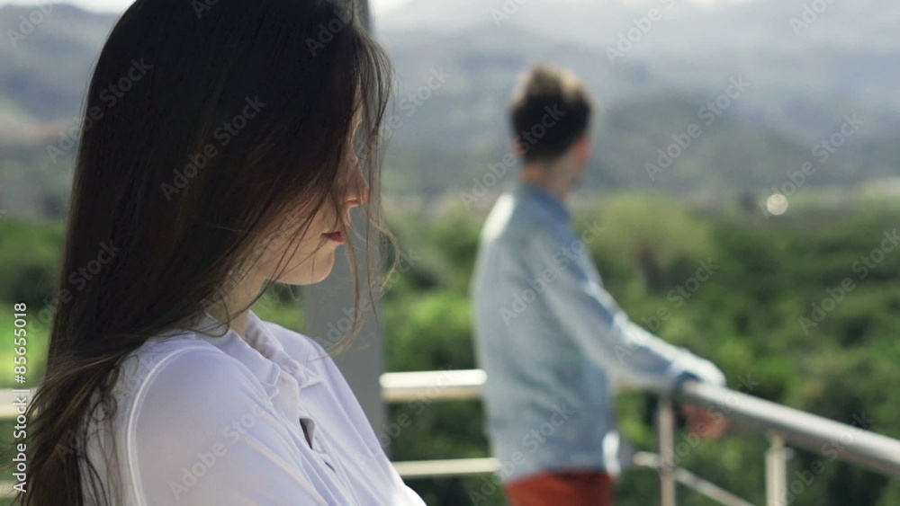 Unhappy, offended couple standing on terrace
Unhappy, offended couple standing on terrace