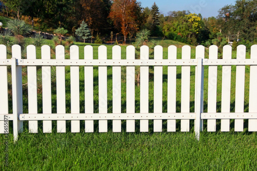 White fence on green grass.