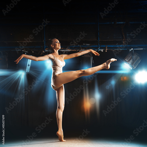 Sweet blonde ballerina on stage in theater posing